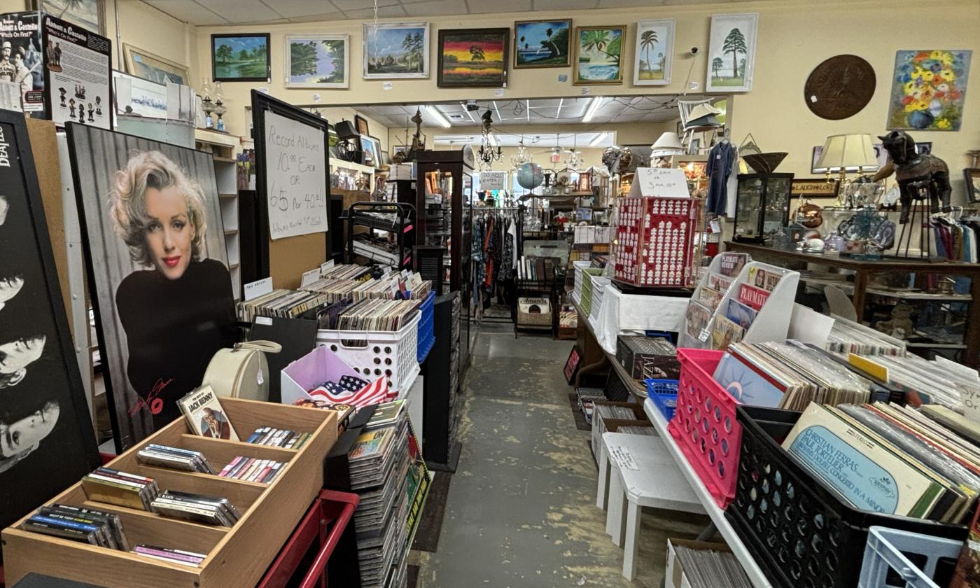 Records, posters, and paintings are displayed around the shop