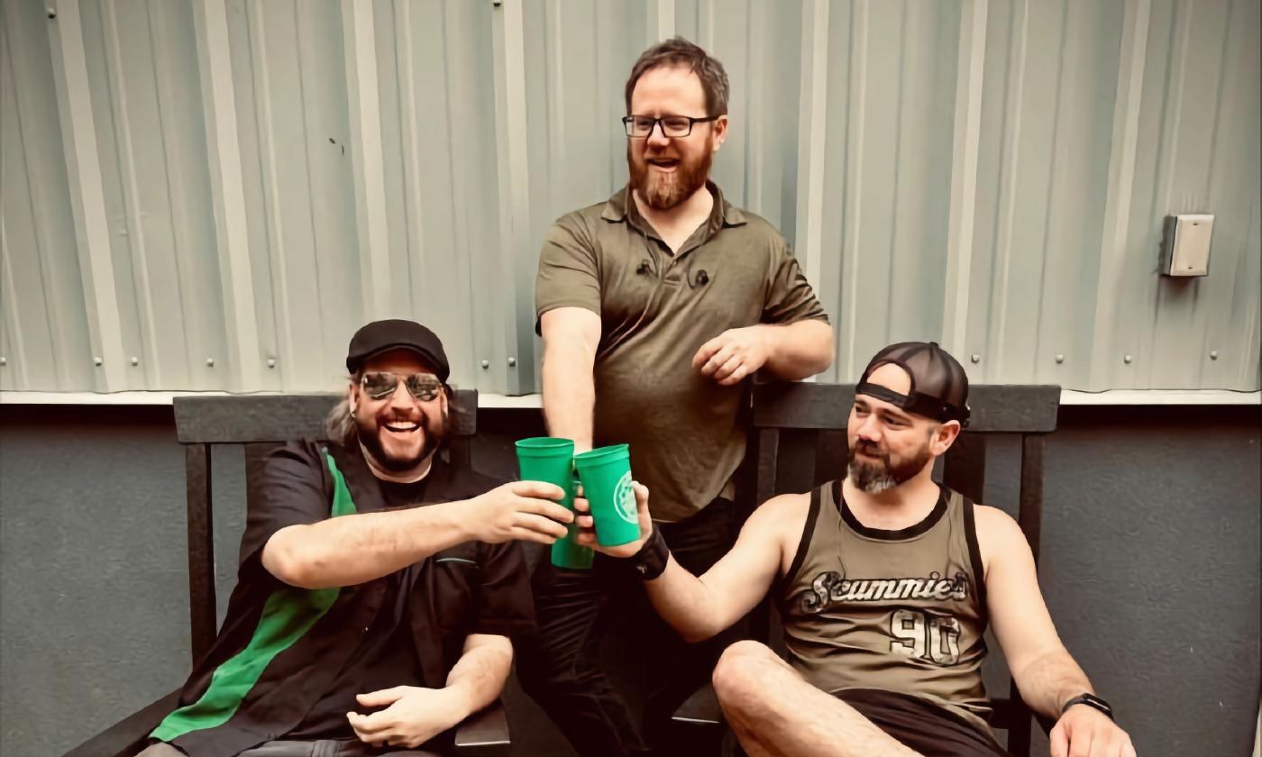 Three members of a punk Celtic band, in toasting with green cups