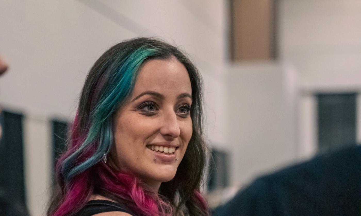 Megan McKenzie, with colorful hair and a warm smile, before a gig