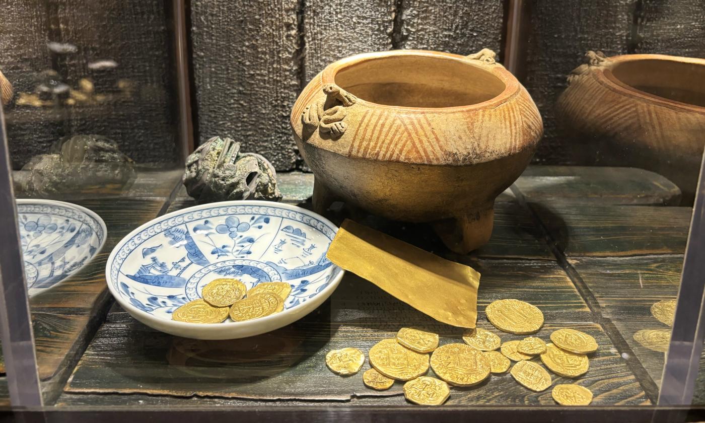 A display of gold coins and old pottery at the Pirate and Treasure Museum