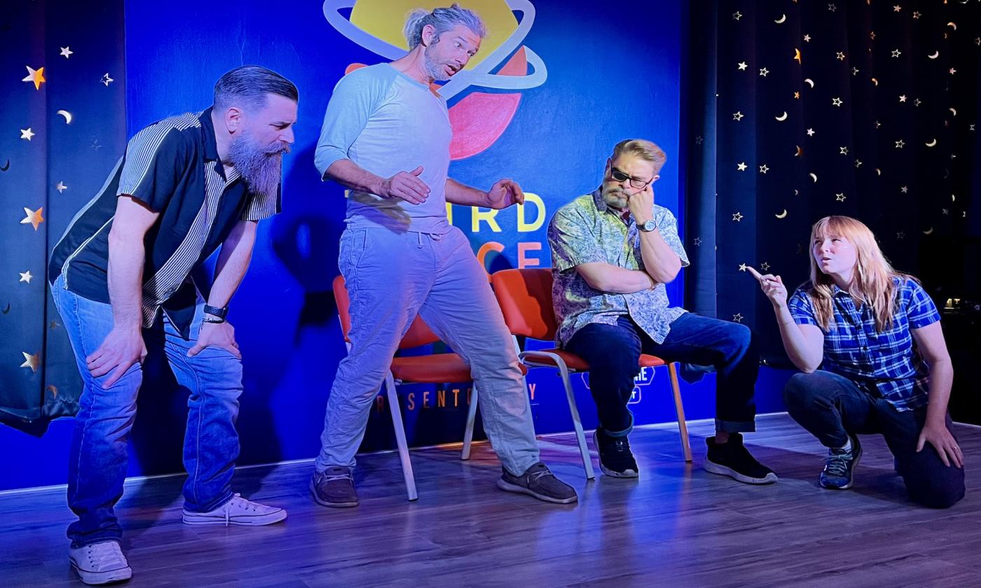 Four comedy improv performers on stage.