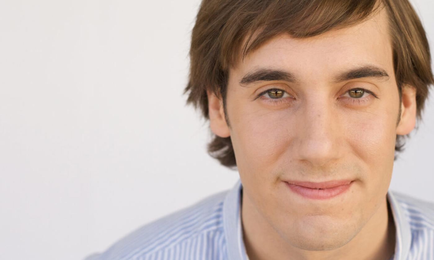 Mike Hanford wears a blue shirt and poses in front of a white backdrop. 