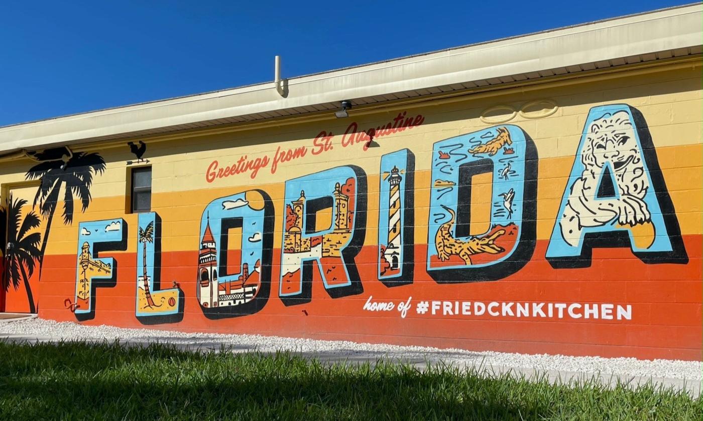 A greetings from Florida mural on the side of a building