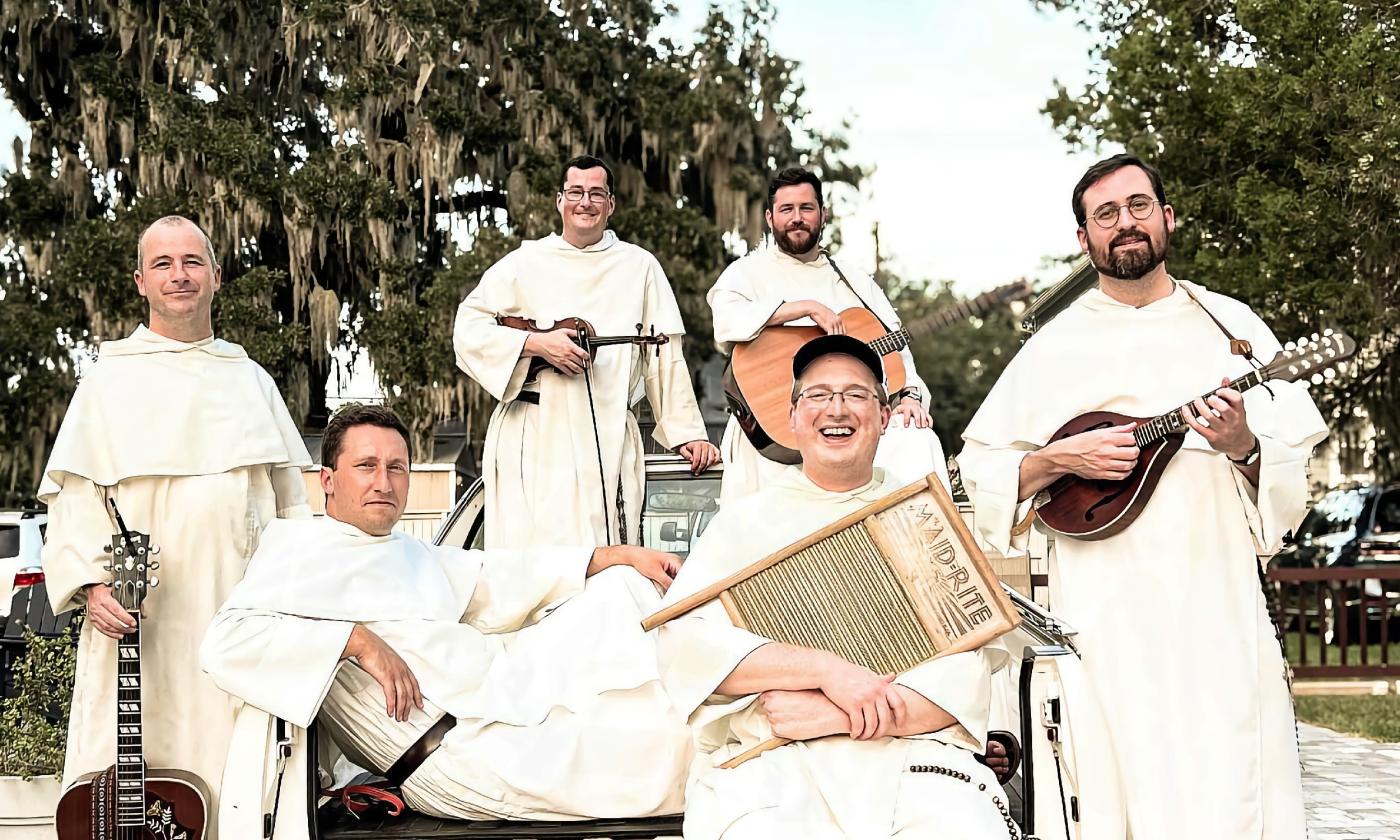 Members of the Hillbilly Thomists, with their instruments in the back of a pick-up truck