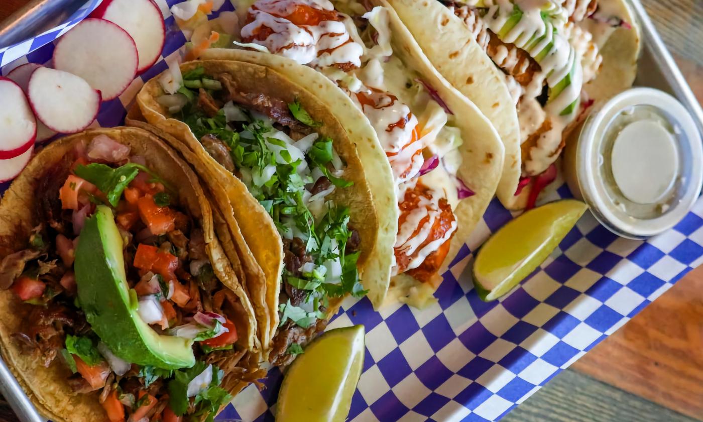 A tray of tacos with various toppings