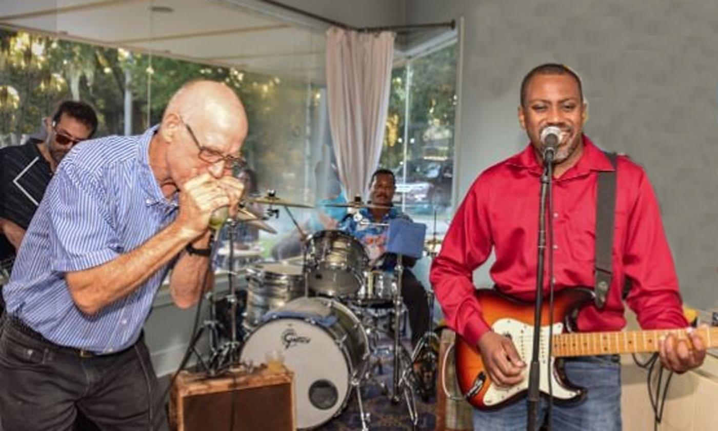 Brett Barnard and the Hitman Band playing onstage: guitarist and harmonica player