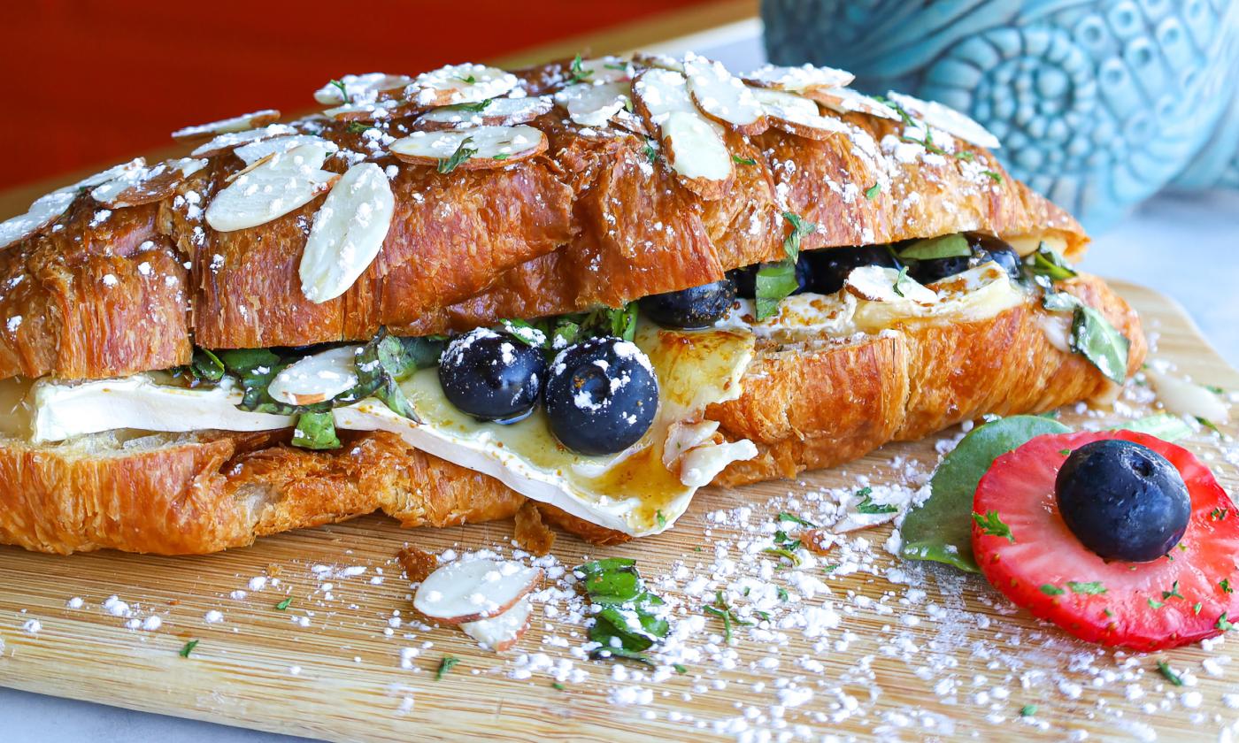 This beautifully presented croissant sandwich is served with fresh fruit