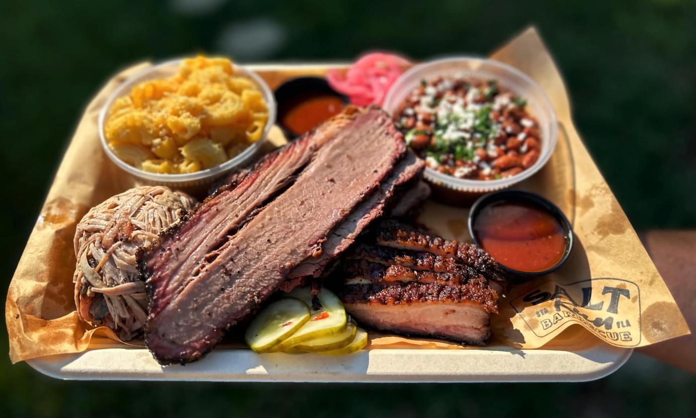 A tray of meats, mac 'n' cheese, and baked beans