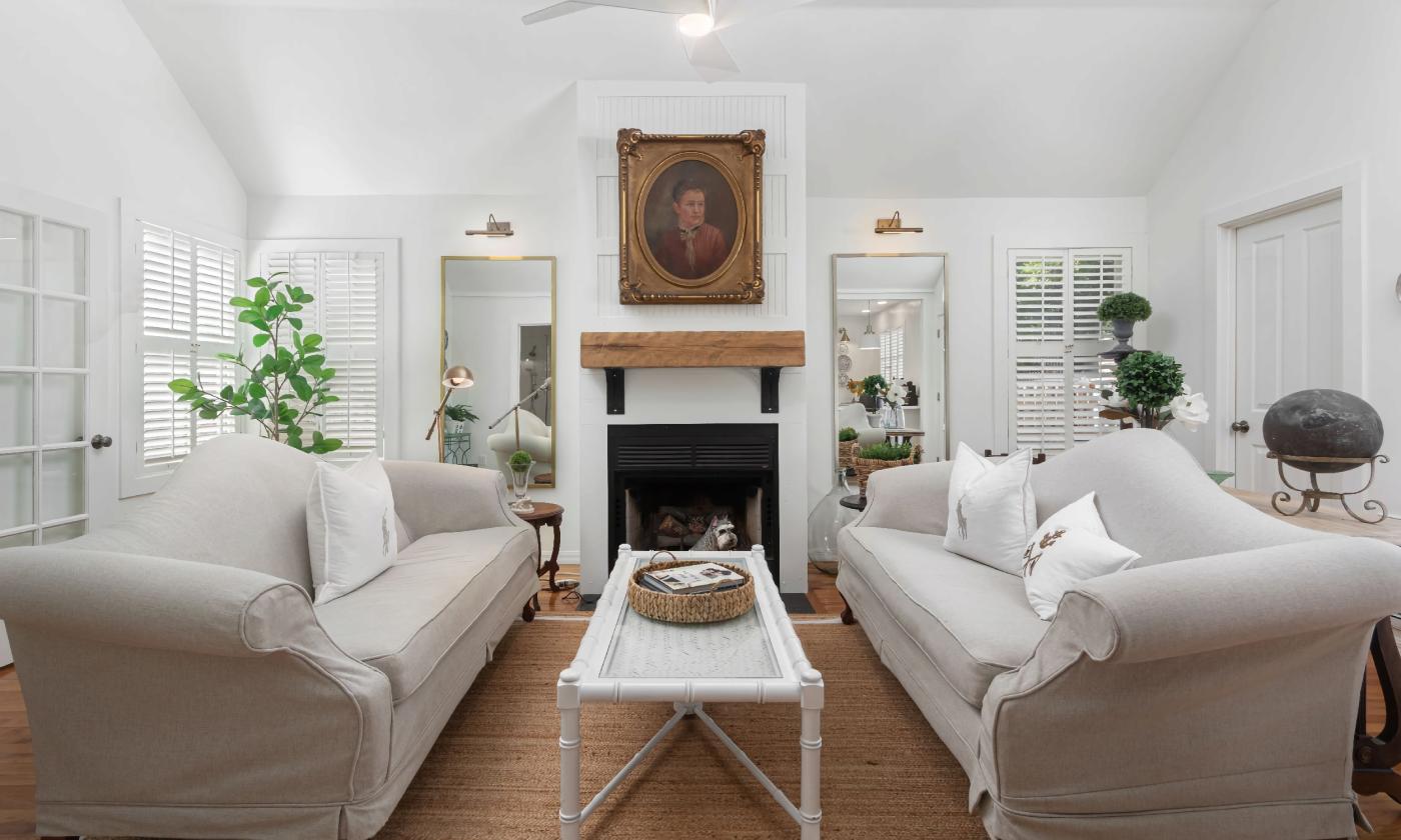 A beautiful living room with facing sofas in front of a fireplace with a wood mantle