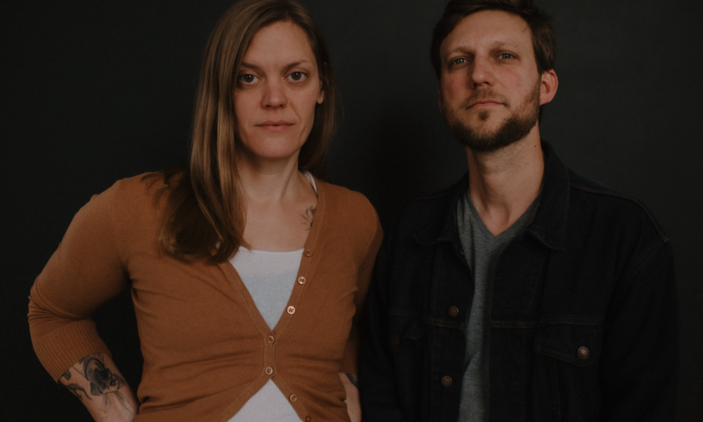 Bandmates from The Rough & Tumble pose in front of a black backdrop.