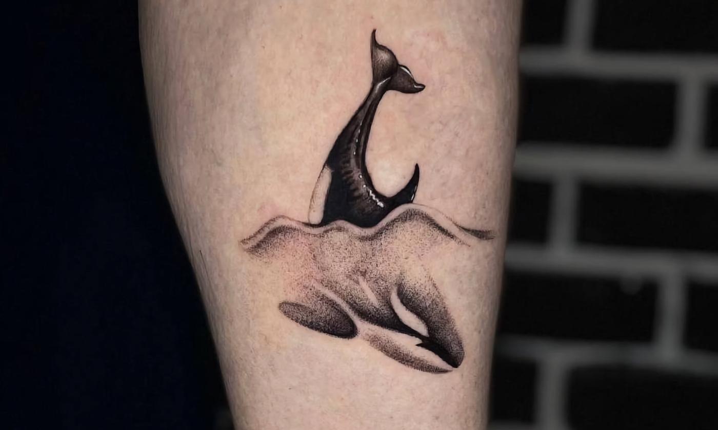 A black and grey whale tattoo