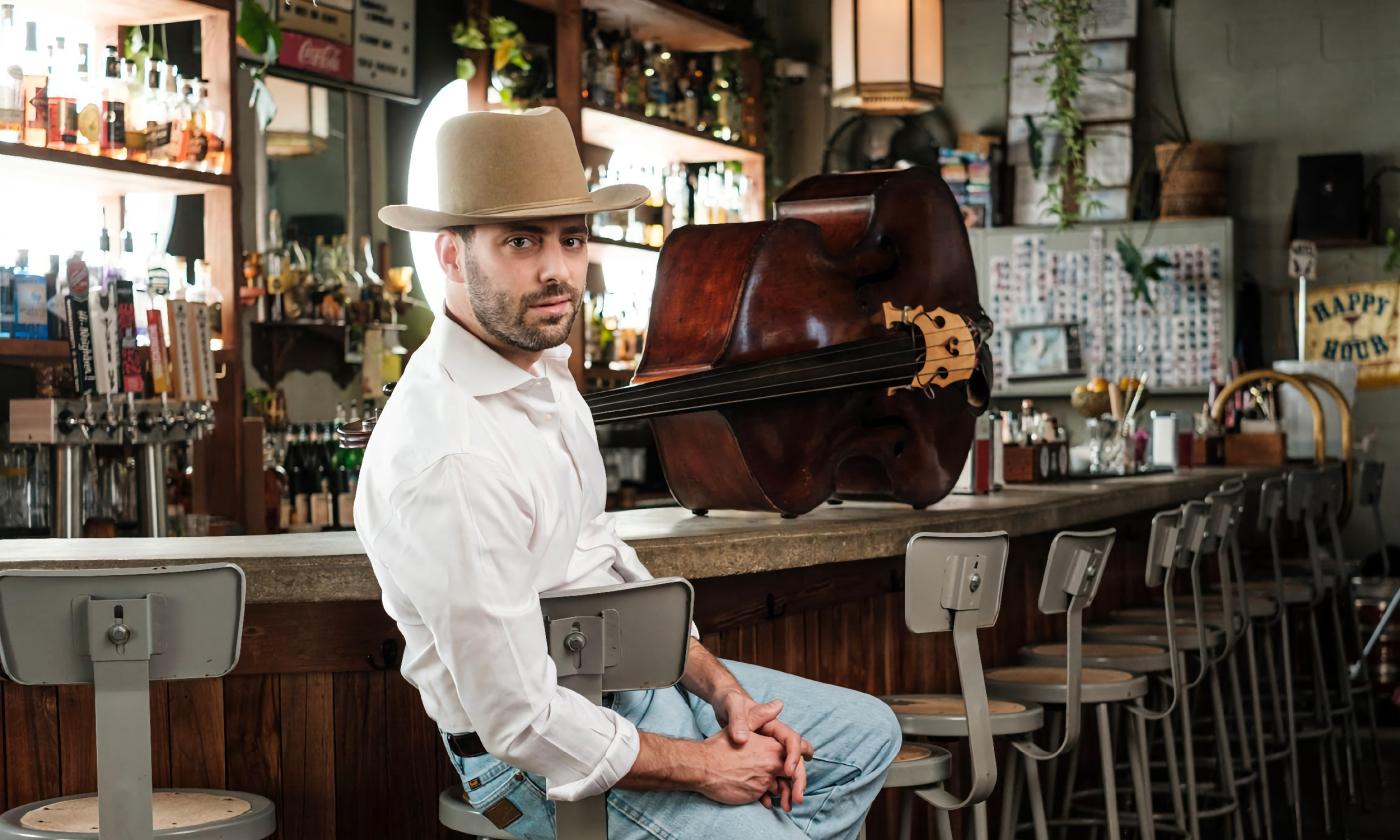 Jeff Picker, sitting at a bar with his acoustic bass on the counter