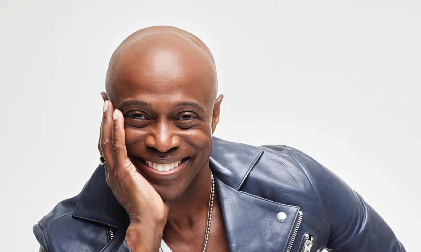 The musical artist and author KEM, in blue leather on a white background