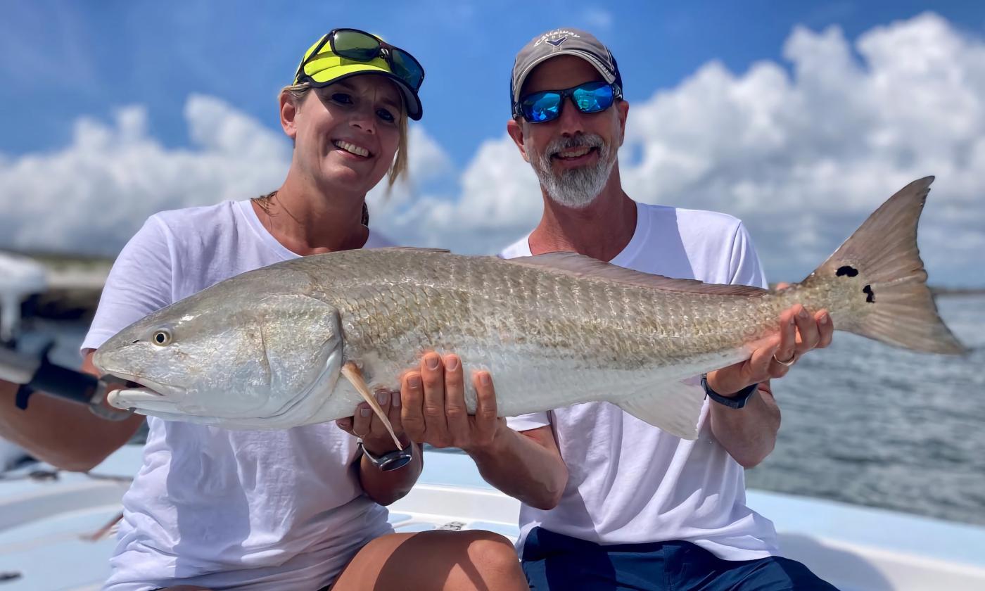 A couple holding up a fish