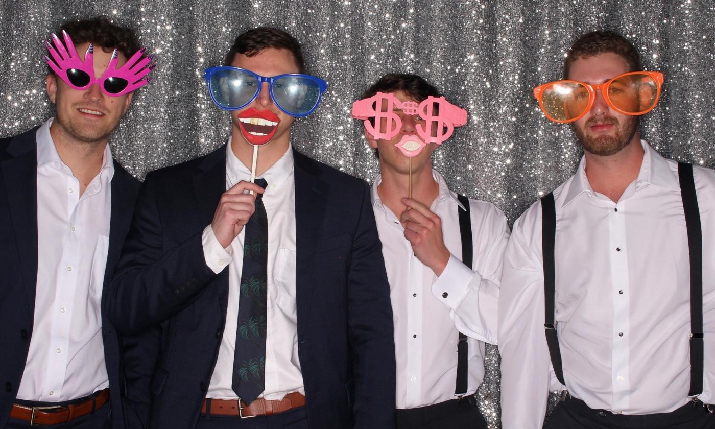 A group of men acting goofy in a photo booth