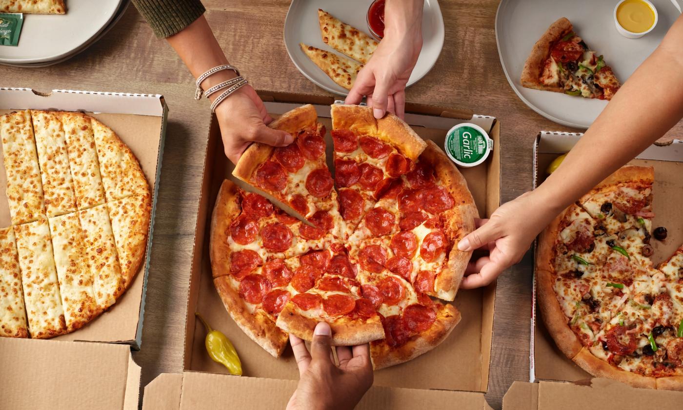 A spread of pizzas and cheesesticks from Papa John's