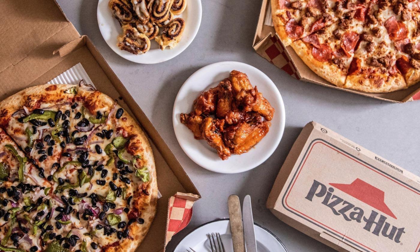 A spread of pizza, wings, and Cinnabon rolls