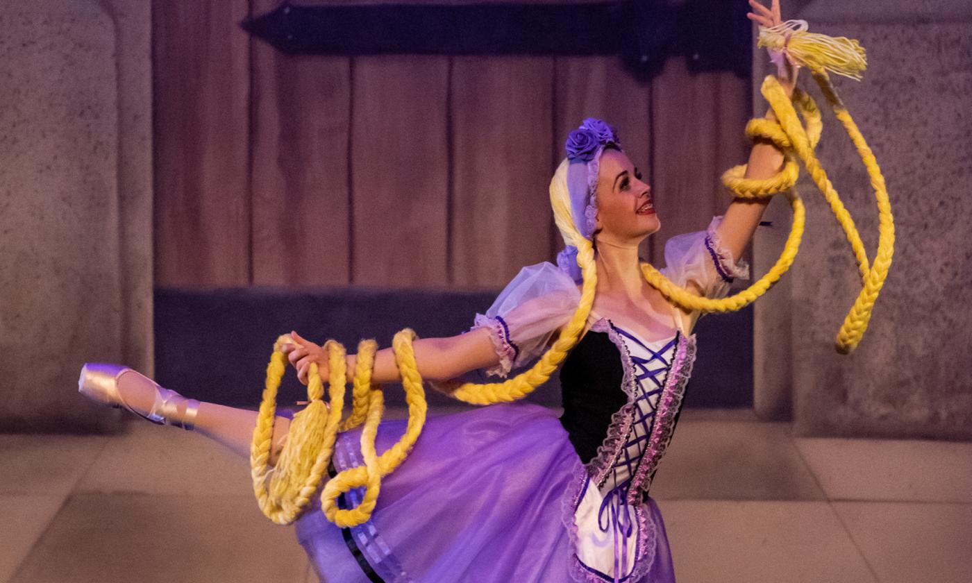 A dancer in a ballet pose dressed as Rapunzel