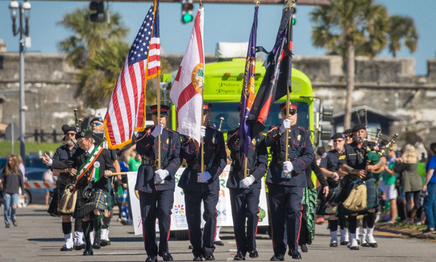 The parade steps out with the honor guard followed by bagpipers