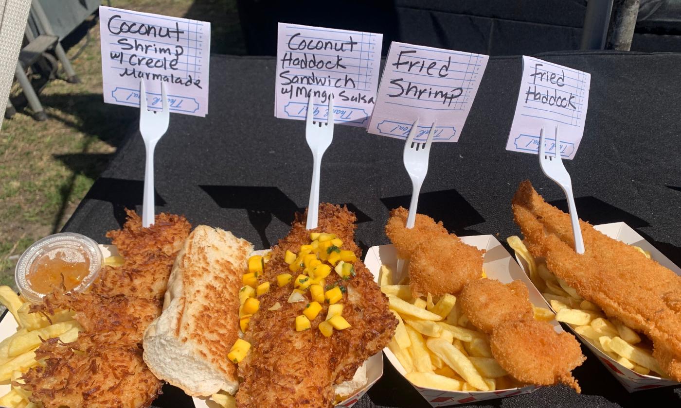 Four different fried seafood dishes with notes on forks describing each dish