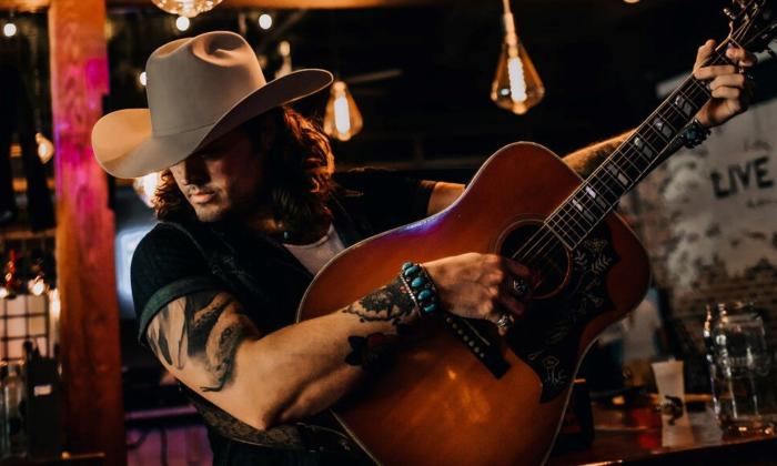 Justin Biltonen strums the guitar. 