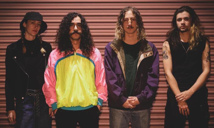 The band Naum from Florida pose in front of a garage door