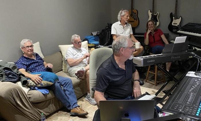 The jazz band Swing and a Miss smile next to audio equipment in a recording studio