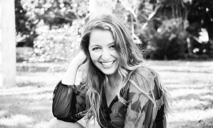 Singer and songwriter Haley Fahey, sitting in a garden, in black and white