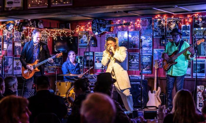 Jason Ricci plays the harmonica on stage with The Bad Kind music band.