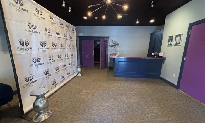 The lobby of Limelight Theatre has blue walls, purple doors and round ceiling lights against a black ceiling