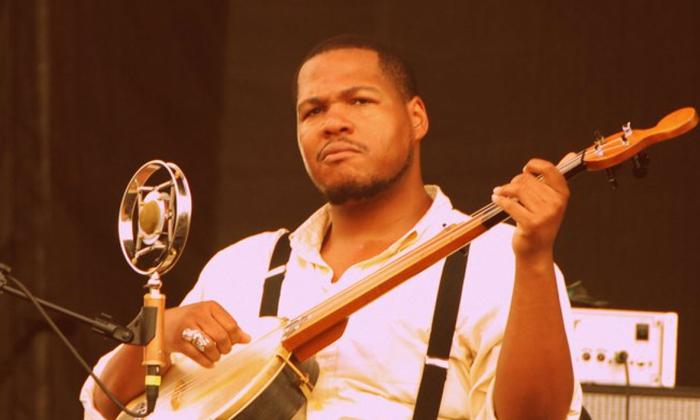 Jerron Paxton playing his banjo, singing.