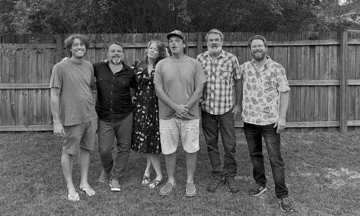 The six members of Uncle Mosie, in a backyard by the fence