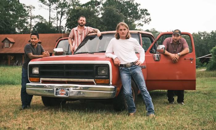 Members of the Chase Ryland Band posing in front of a classic pickup truck