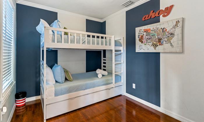 This room with a bunk-bed has color-blocked walls and kid-friendly decor