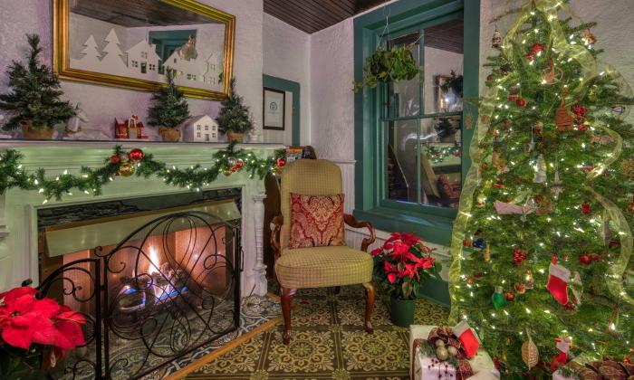 The common room in a local bed and breakfast inn, with a Christmas tree and green adn red decorations