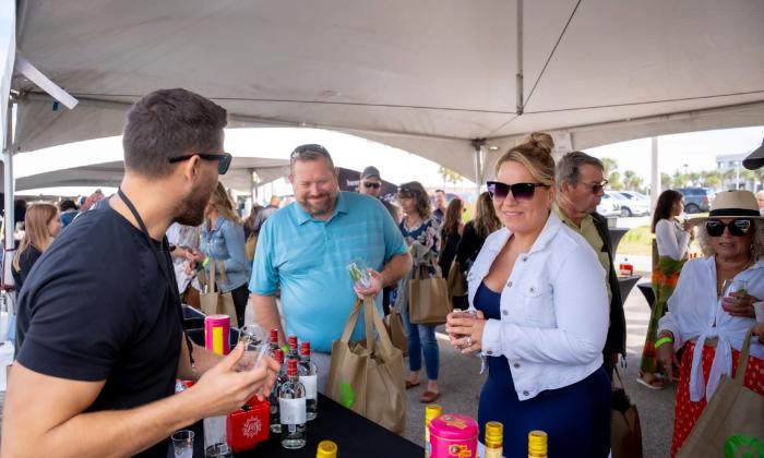 People attending a food and drink festival, get tastings of an adult beverage