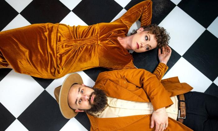 Bandmates from Goldpine lay side by side on a checkered floor.