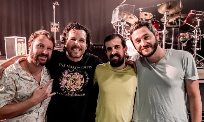 The four-male band Spafford, leaning together, smiling