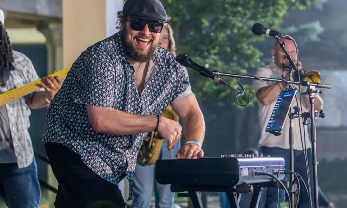 Victor Wainwright smiles and plays the keyboard for fans.