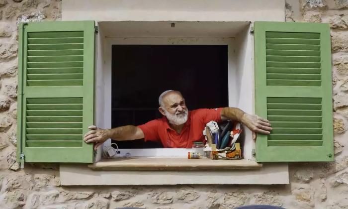 A man looking out the window in "Xueta Island"