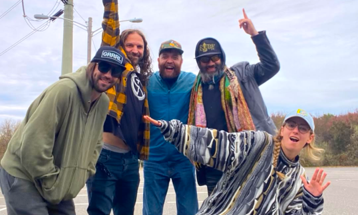 Bandmates from Bearly Dead smile and pose in front of electric poles and telephone lines.