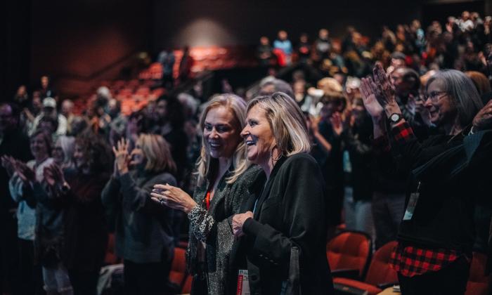 Two women standing an applauding in an audience at the St. Augustine Film Festival