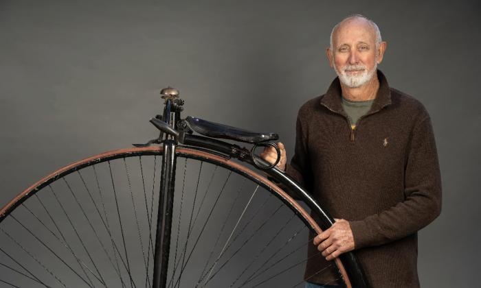 Keith Pariani standing next to one of his high-low bicycles