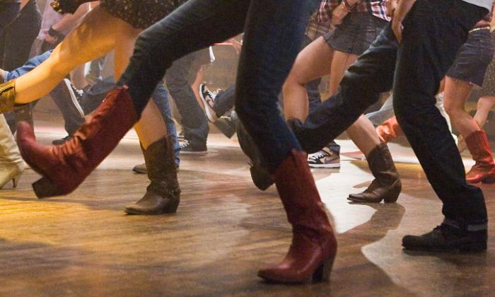 People kicking their feet in a line dancing class