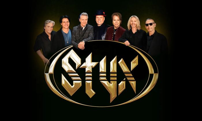 Bandmates from Styx smile and pose in front of a black backdrop.