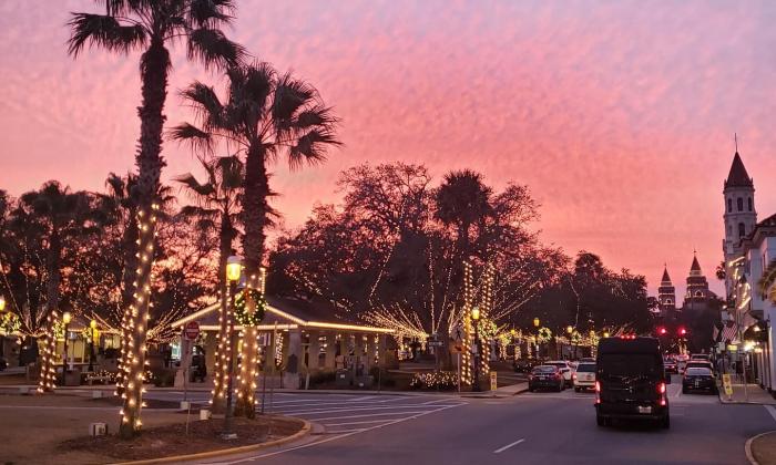 The plaza in st. Augustine, lit for Nights of Lights, at dusk under a pink sky