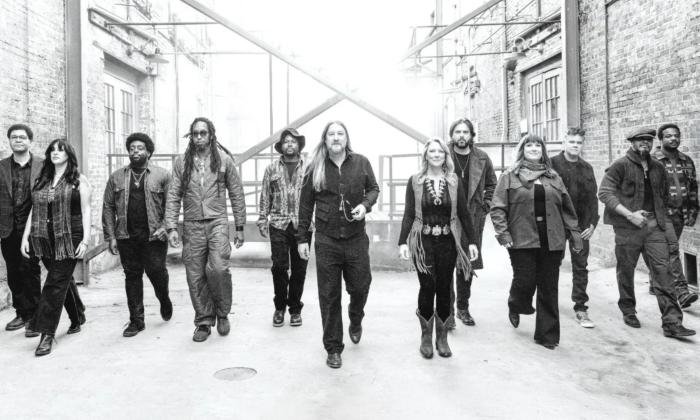 Bandmates from Tedeschi Trucks wear dark clothing and pose in a black-and-white photograph.
