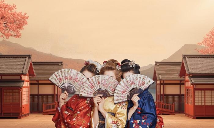 The set of a production of "The Mikado" with the three women chorus holding fans over their faces