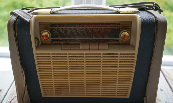 An old radio from the mid-century, on a picnic table