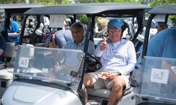 Two golfers in their cart, ready for the start of the Southeast Coil Classic